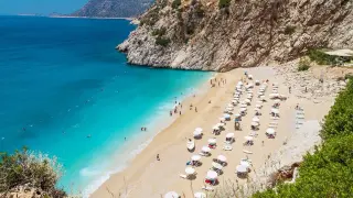 Piękna plaża z turkusową wodą, leżakami i parasolami. Idealne miejsce na relaks i odkrywanie konakli atrakcje.