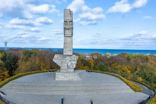 Pomnik Obrońców Wybrzeża na Westerplatte. Zwiedzanie tego miejsca to lekcja historii. W tle morze i jesienne drzewa.