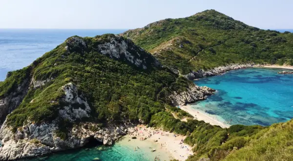 Malownicze zatoczki i piaszczyste plaże Korfu, otoczone zielonymi wzgórzami i krystalicznie czystą wodą. Idealne miejsce na relaks.