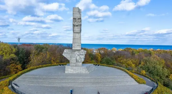 Pomnik Obrońców Wybrzeża na Westerplatte. Zwiedzanie tego miejsca to lekcja historii. W tle morze i jesienne drzewa.