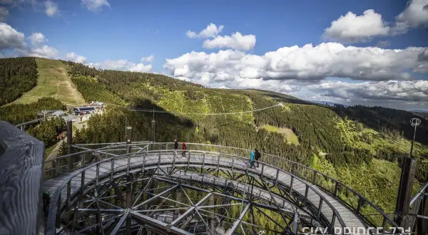 Spacer w chmurach Czechy. Drewniana kładka Sky Bridge 721 w Dolní Moravie wznosi się nad zielonymi lasami i górami.