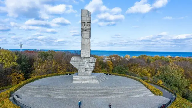 Pomnik Obrońców Wybrzeża na Westerplatte. Zwiedzanie tego miejsca to lekcja historii. W tle morze i jesienne drzewa.